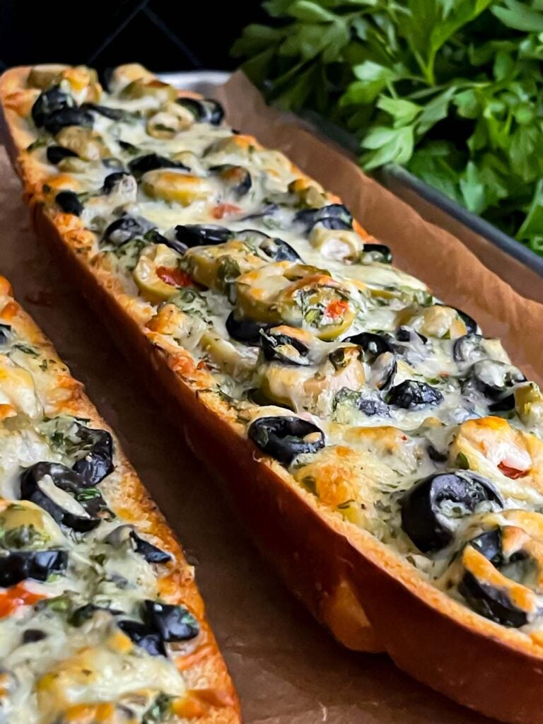 Olive cheese bread on a parchment paper lined baking sheet.