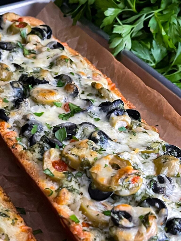 Olive cheese bread on a parchment paper lined baking sheet.