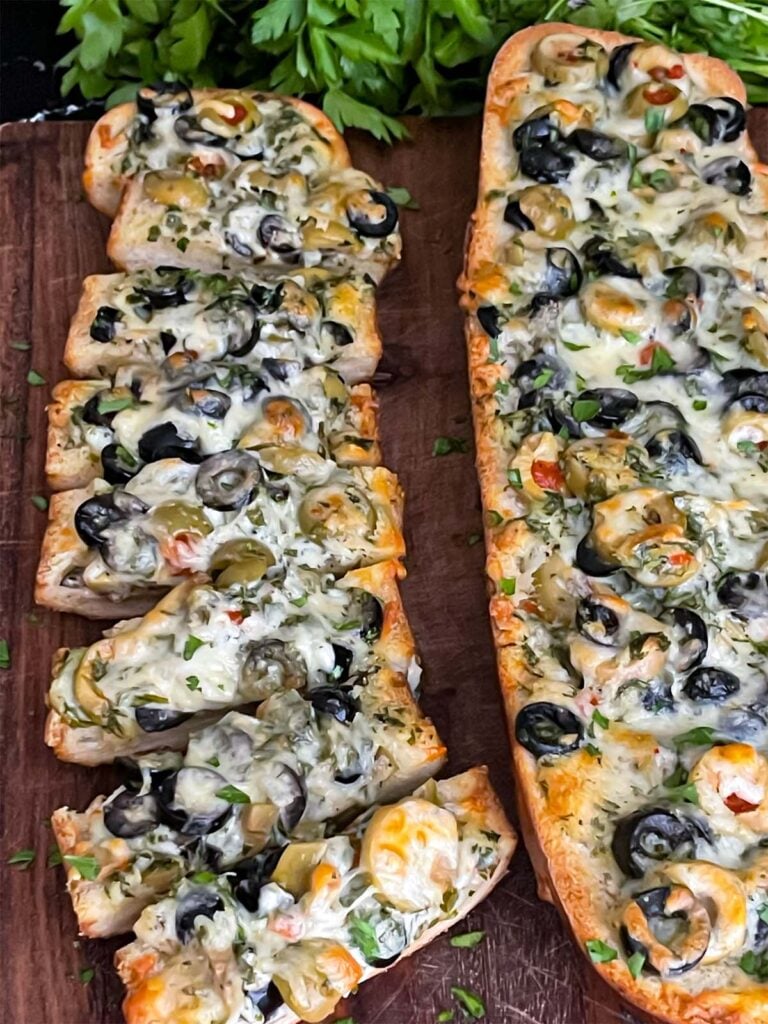 Olive cheese bread on a wooden cutting board.