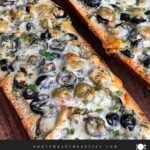 Olive cheese bread on a wooden cutting board.