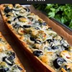 Olive cheese bread on a wooden cutting board.