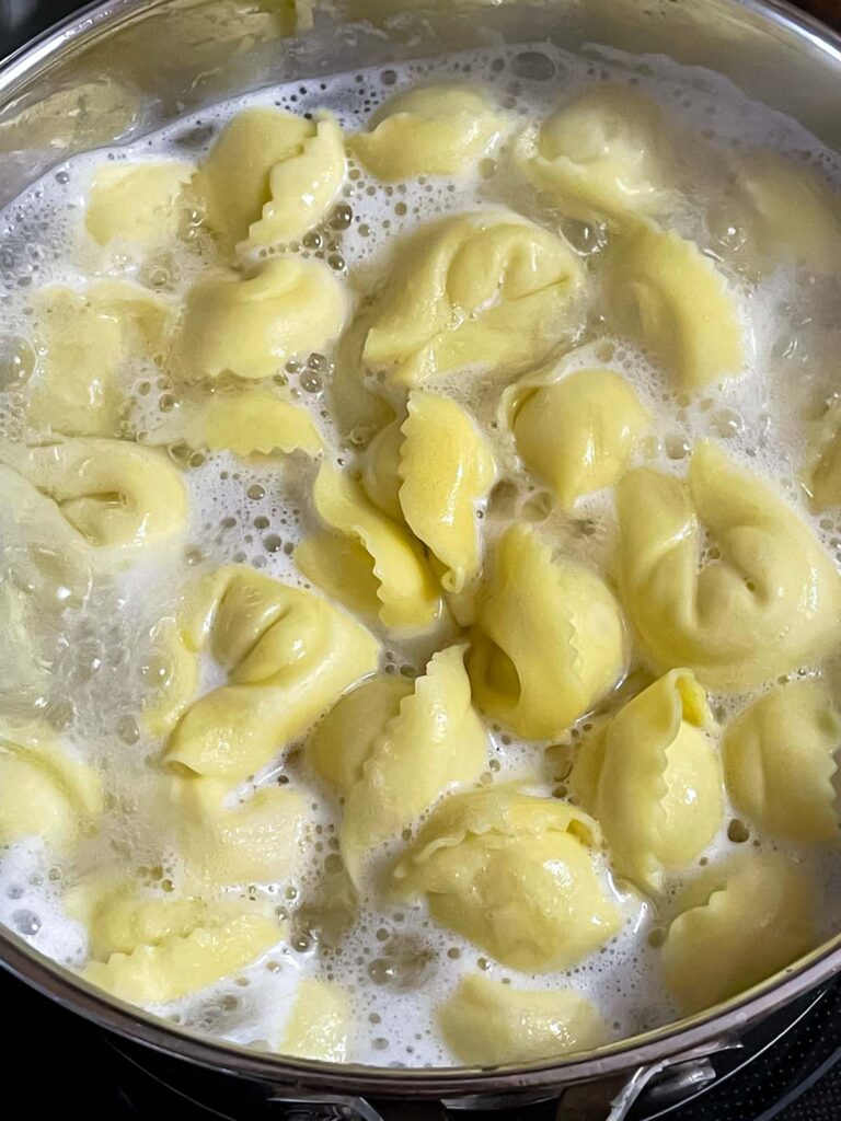Tortellini boiling in a pot of water.