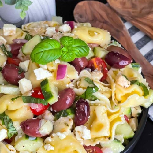 Tortellini pasta salad in a dark bowl.