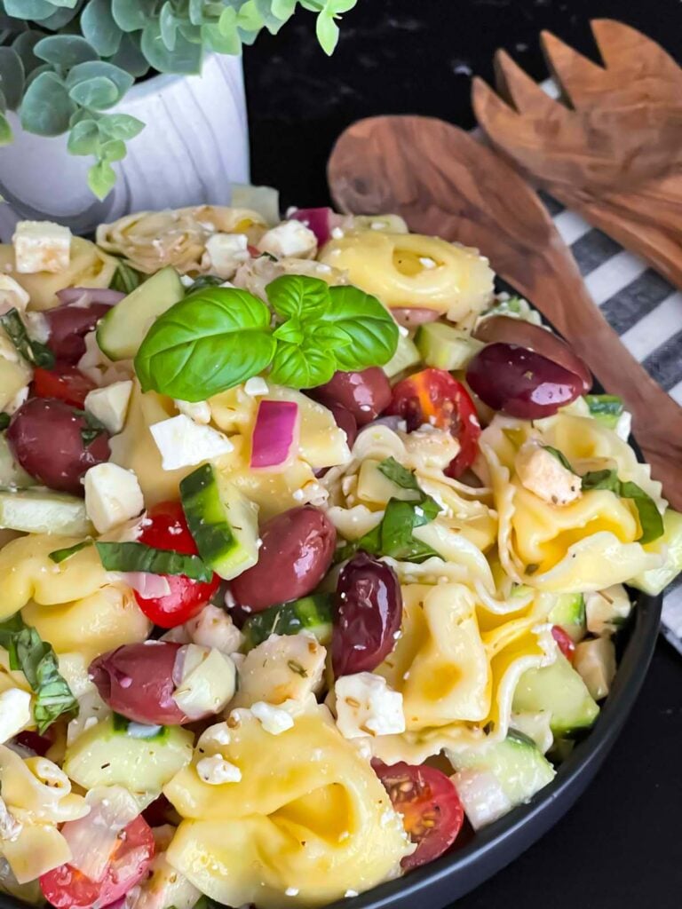 Tortellini pasta salad in a dark bowl.