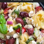Tortellini pasta salad in a dark bowl.