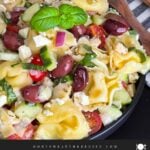 Tortellini pasta salad in a dark bowl.