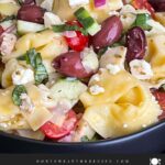 Tortellini pasta salad in a dark bowl.