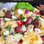 Tortellini pasta salad in a dark bowl.