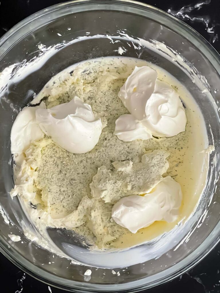 Sour cream and dry ranch seasoning mix added to the smooth cream cheese for the veggie roll ups recipe.