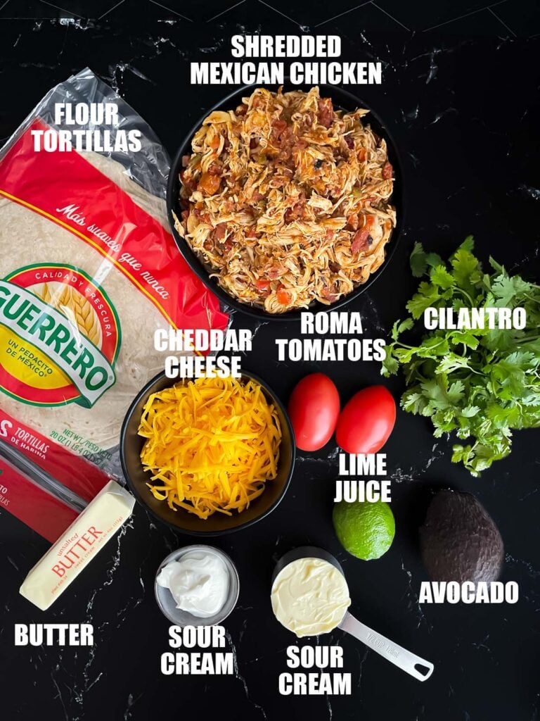 Baked chicken chimichanga recipe ingredients on a dark surface.