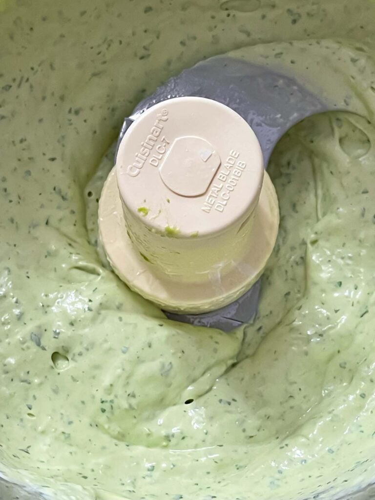 Avocado crema blended in a food processor bowl.