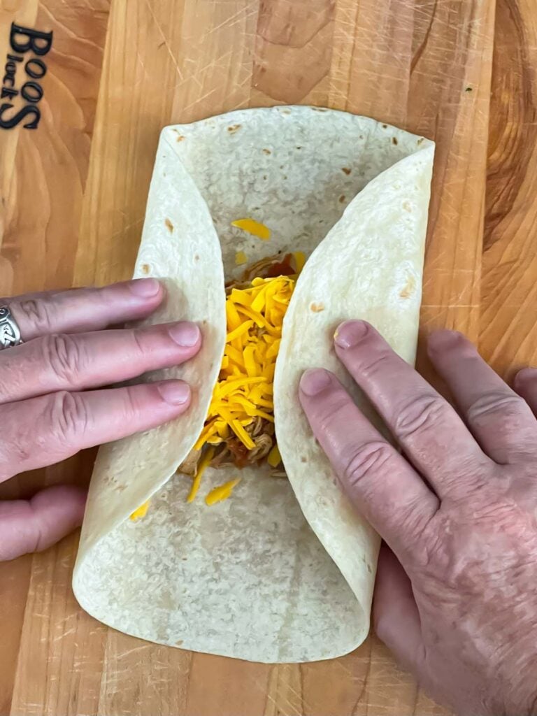 Sides folded in on the tortilla on a wooden board.