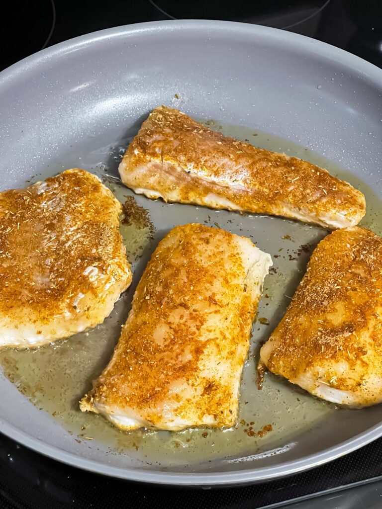 Fish cooking in a skillet.