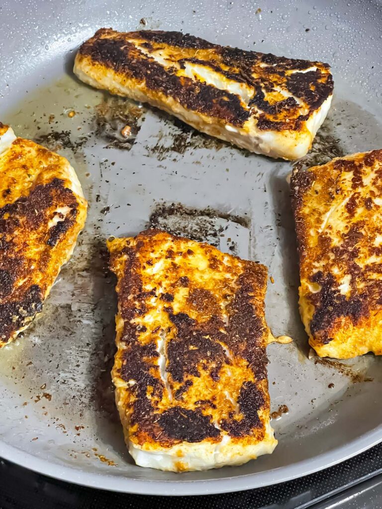 Blackened fish in a skillet.