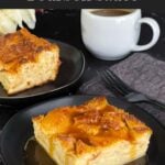 Bread pudding on a dark plate with a bourbon sauce drizzled over it.