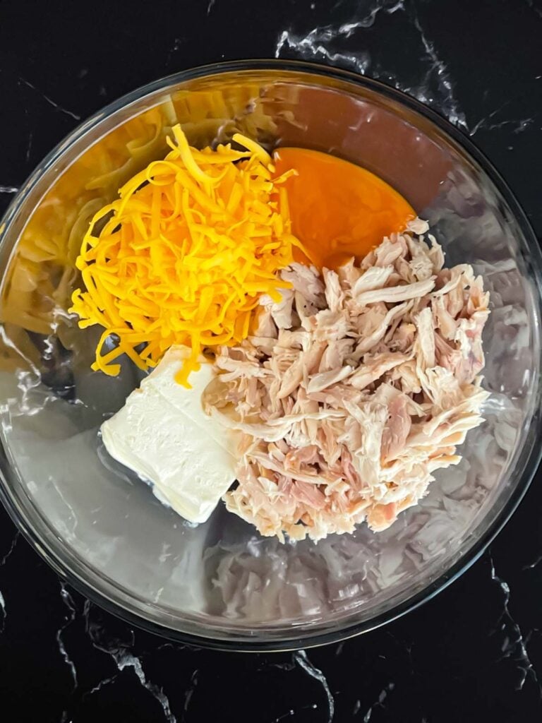 Ingredients for buffalo chicken wonton cups in a glass bowl.