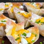 Buffalo chicken wontons garnished with chives and blue cheese crumbles on wooden cutting board.