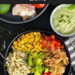 A chicken burrito bowl with an avocado sauce on a dark background.