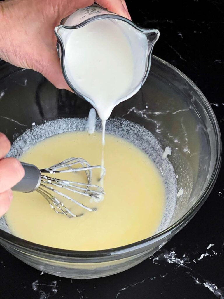 Buttermilk being whisked into the melted butter for the herb and cheese muffins recipe.