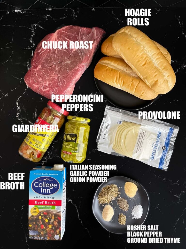 Slow cooker Italian beef sandwiches recipe ingredients on a dark surface.