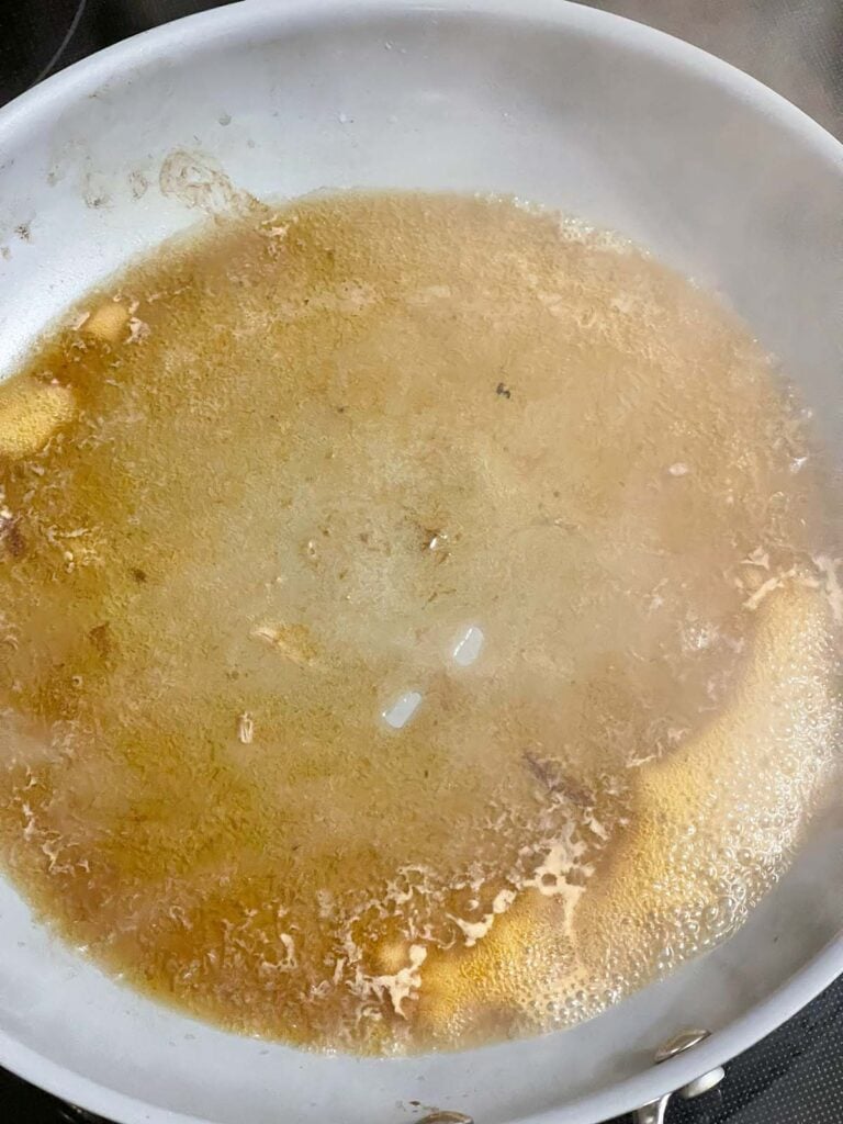 Beef broth deglazing the skillet used to sear chuck roast.