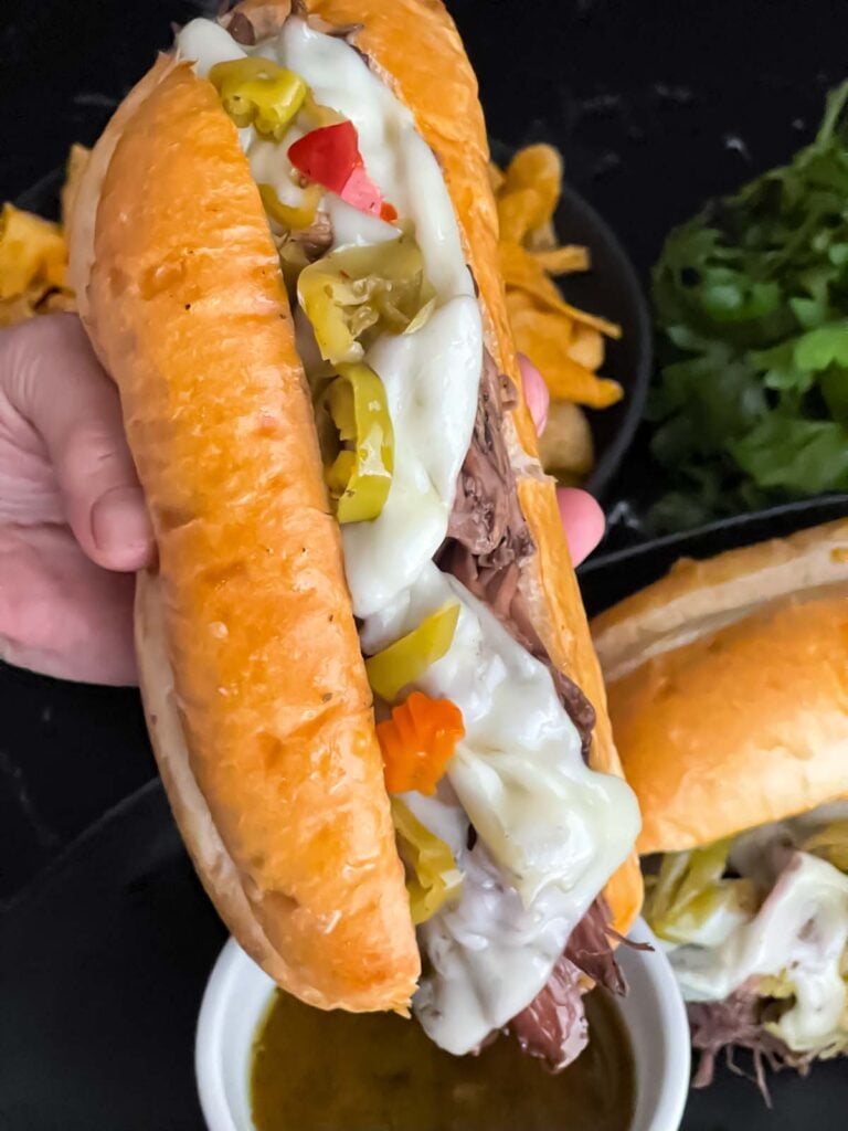 Italian beef sandwich over a ramekin of au jus.