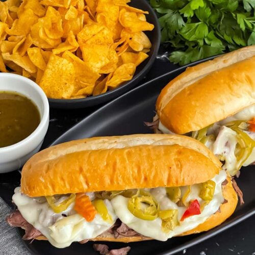 Italian beef sandwiches on a dark plate.