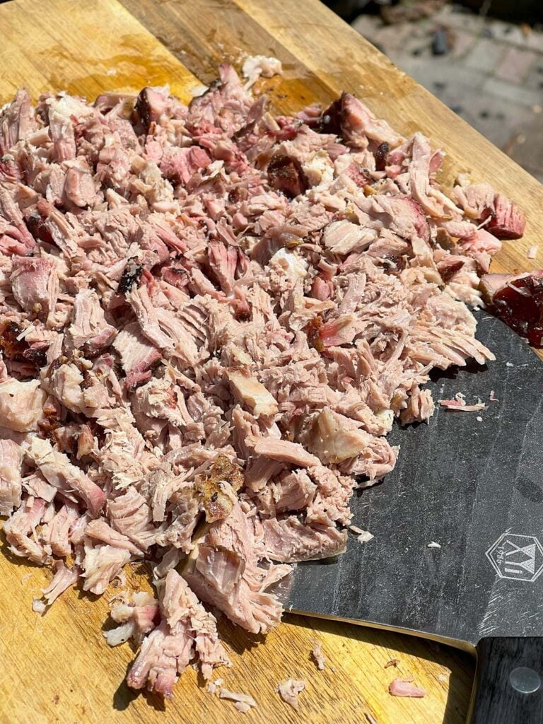 Chopped pork butt on a cutting board.