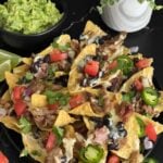 Pulled pork nachos with red onion, tomato, and jalapeno.