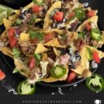 Pulled pork nachos with red onion, tomato, and jalapeno.