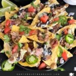 Pulled pork nachos with red onion, tomato, and jalapeno.