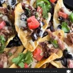 Pulled pork nachos with red onion, tomato, and jalapeno.