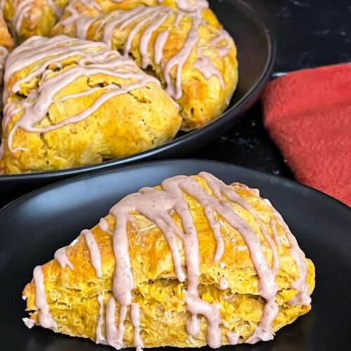 Pumpkin scones a dark plate on a dark surface.