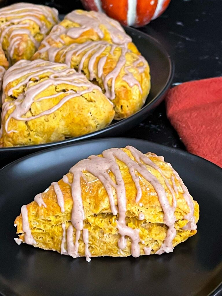 Pumpkin scones a dark plate on a dark surface.