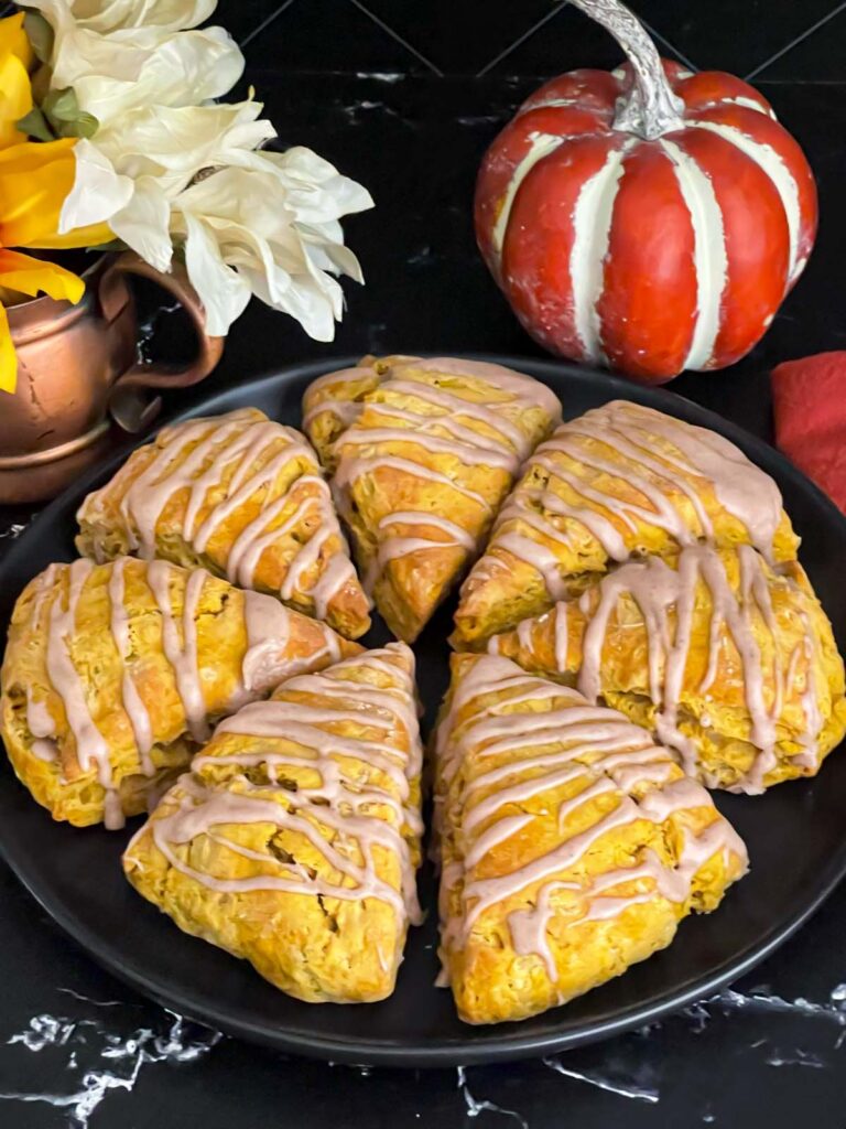 Pumpkin scones a dark plate on a dark surface.