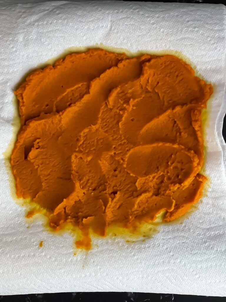 Pure pumpkin puree spread in a thin layer over a paper towel lined plate.