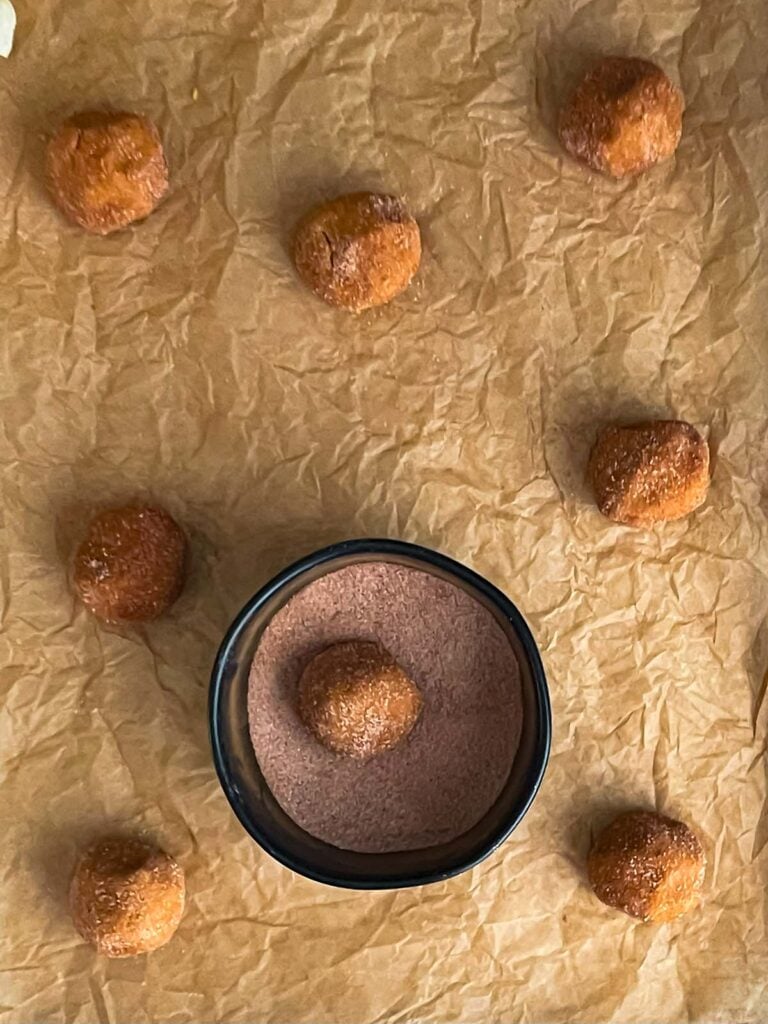 Pumpkin Snickerdoodle cookie dough balls on a parchment paper lined cookie sheet.