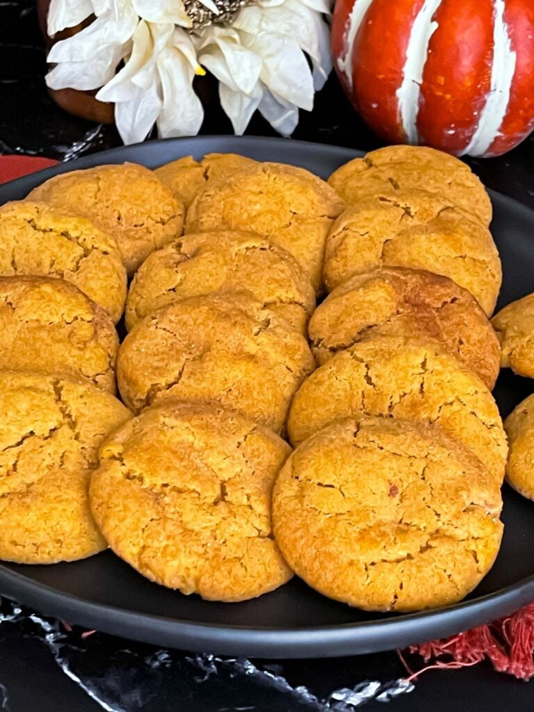 Pumpkin Snickerdoodles on a dark plate on a dark surface.