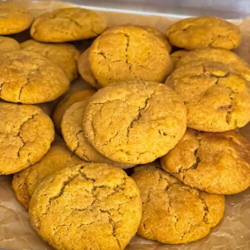 Pumpkin Snickerdoodle cookies on a parchment paper lined baking sheet.