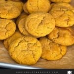 Pumpkin Snickerdoodle cookies on a parchment paper lined baking sheet.