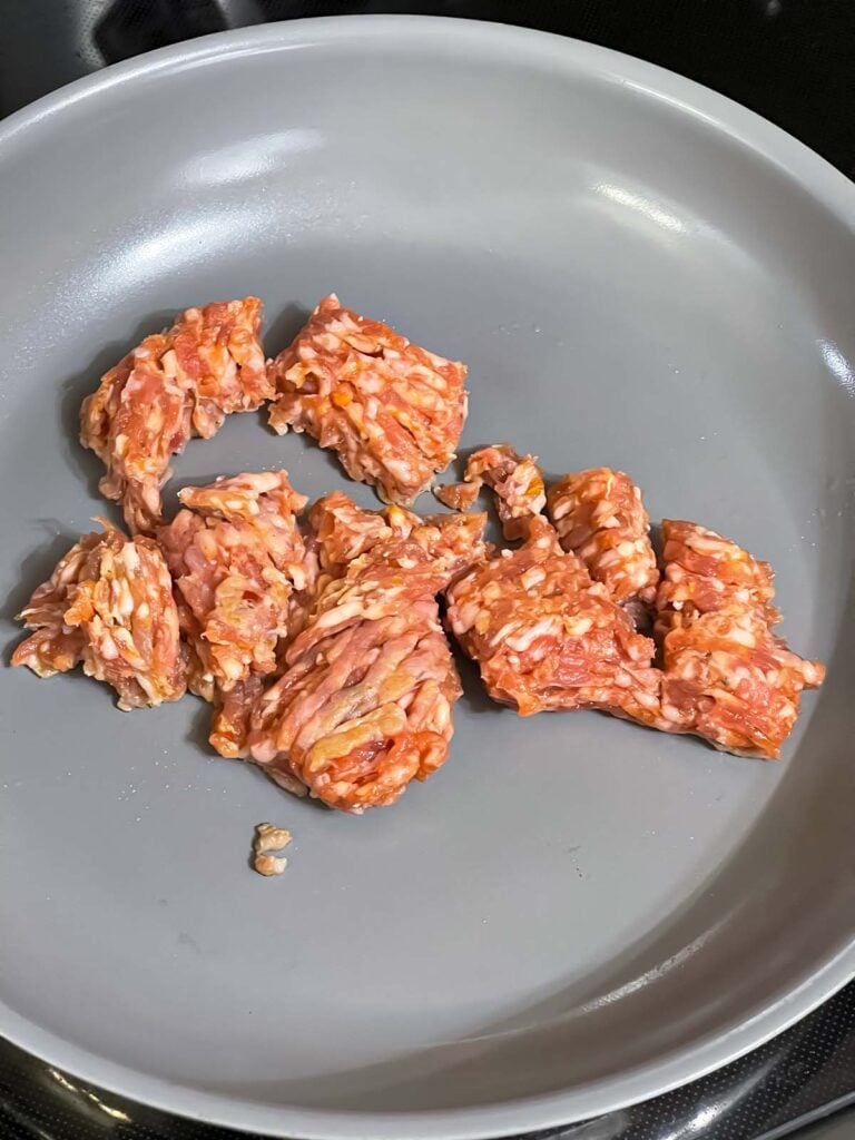 Sausage cooking in a skillet.