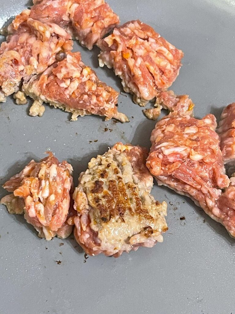 Sausage cooking in a skillet.