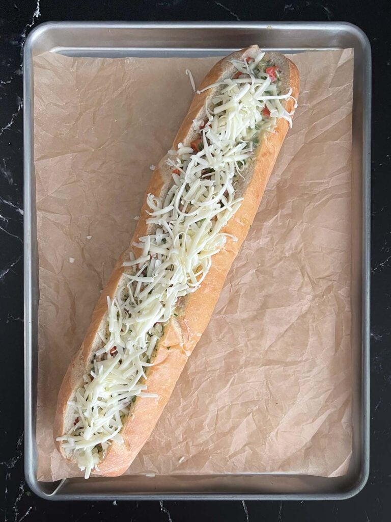 An egg mixture added to a hollowed out french bread loaf topped with cheese.