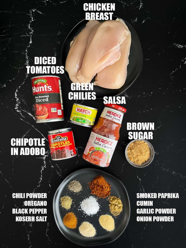 Slow cooker Mexican chicken recipe ingredients on a dark surface.