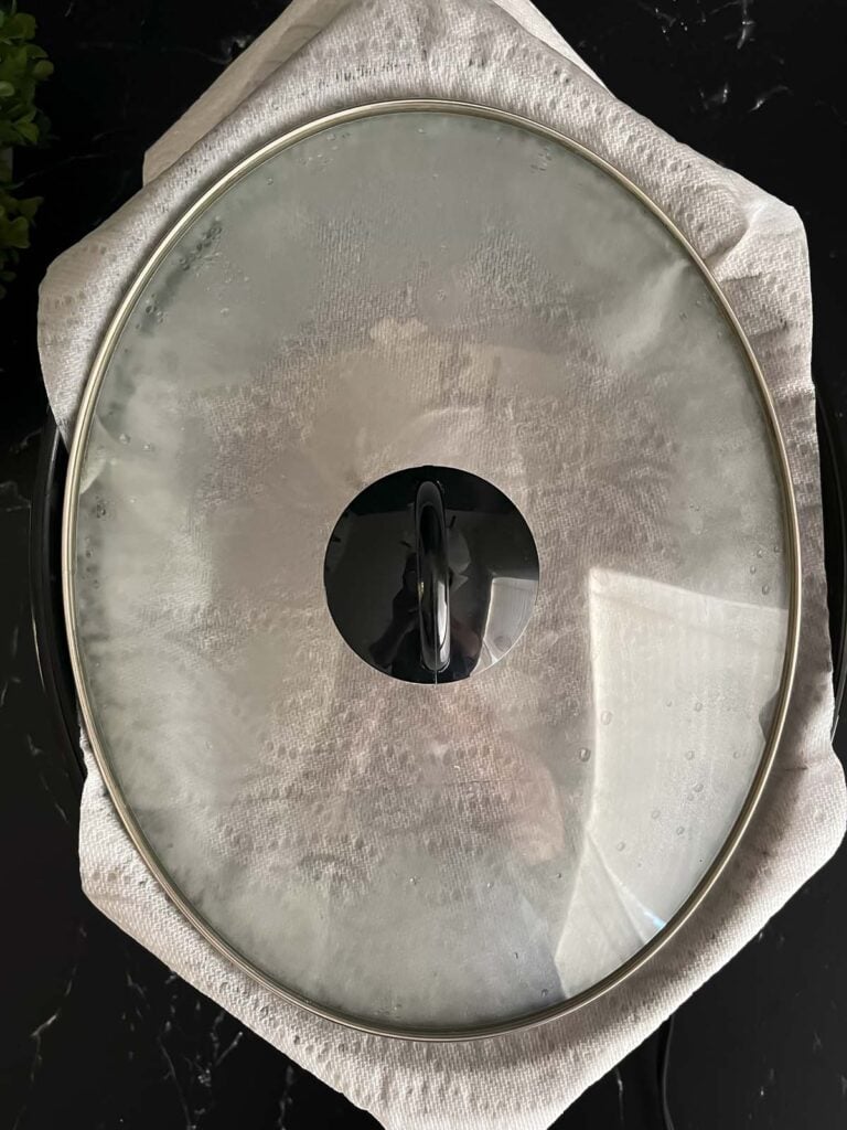Large sheet of paper towels under the lid of the slow cooker.