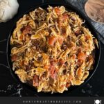 Slow cooker Mexican chicken in a dark bowl on a dark surface.