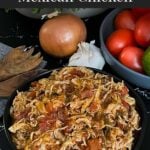 Slow cooker Mexican chicken in a dark bowl on a dark surface.