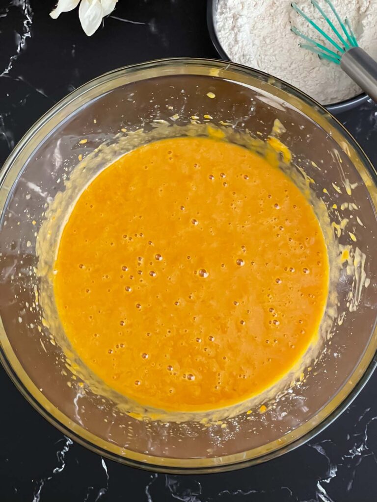 Wet ingredients for sweet potato bread recipe mixed in a glass bowl.