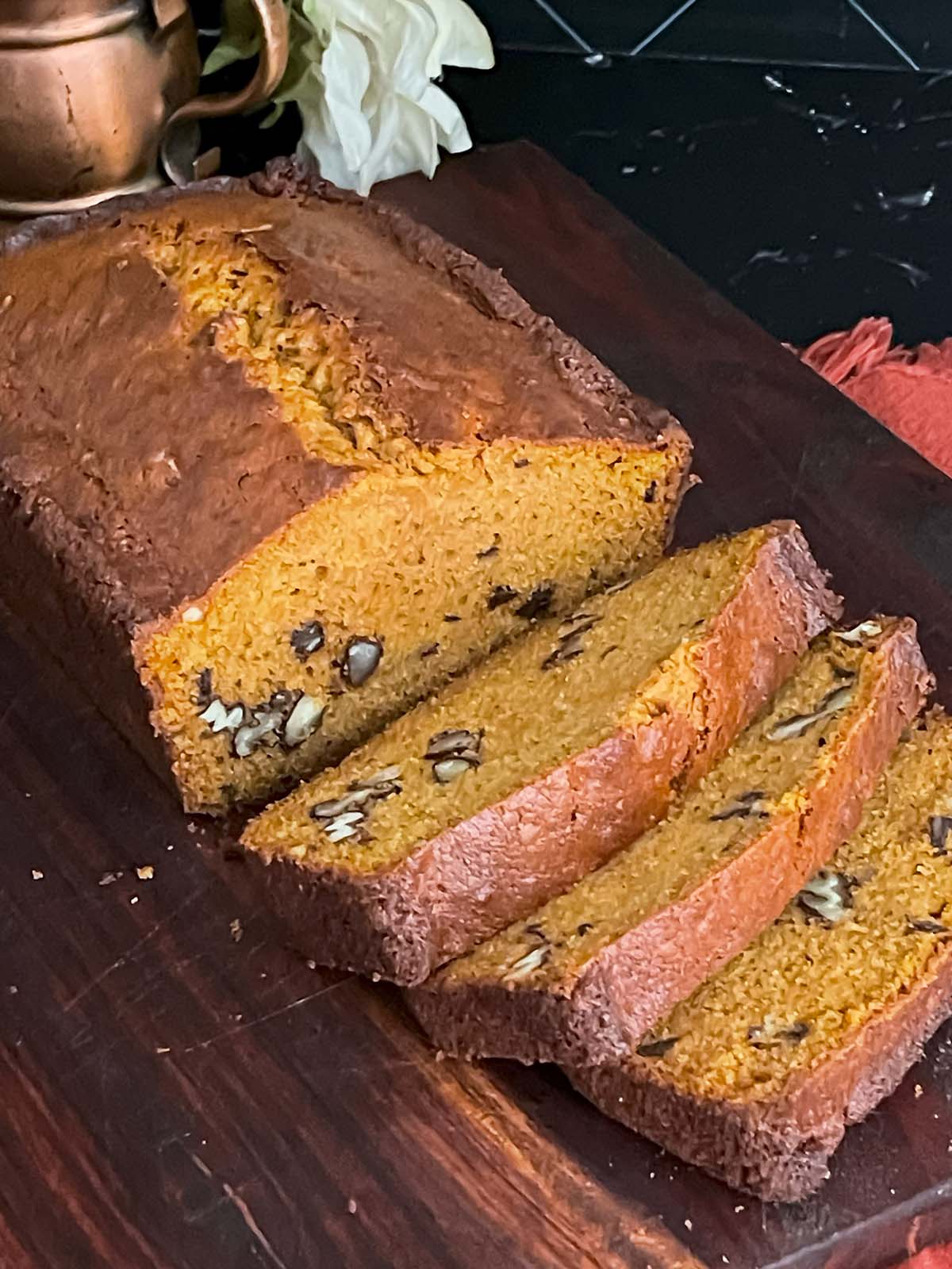 Sliced sweet potato bread on a dark wooden board.