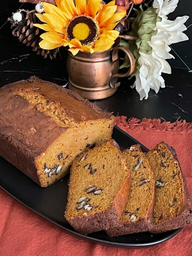 Sweet potato bread sliced on a dark platter.